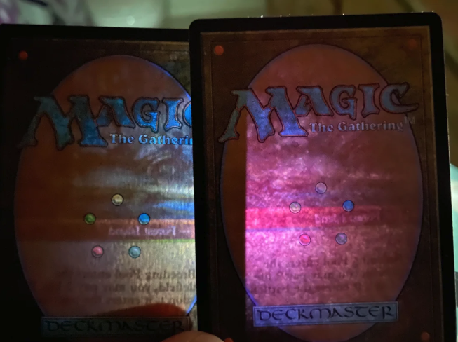Two MTG card backs compared side by side, showing the rosette dot pattern used to print the green mana symbol
